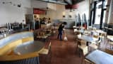 A worker sweeps the ground of an empty Chipotle