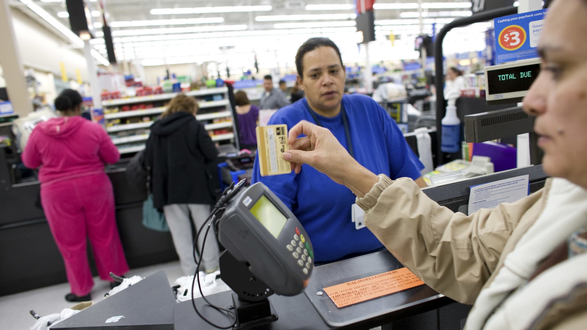 A shopper uses a credit card to pay for her items at a Wal-Mart Supercenter in Denver.