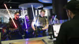 Customers holding lightsabers and dressed as Jedi Knights collect their tickets from the counter at the first public screening of Walt Disney's "Star Wars: The Force Awakens" at a Vue Entertainment cinema in London.