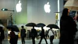 Shoppers walk past the Apple store at the high-end shopping district of Ginza in Tokyo, Japan.