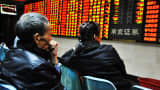 Investors observe stock market at a stock exchange hall