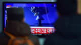 People watch a news report on North Korea's first hydrogen bomb test at a railroad station in Seoul on January 6, 2016. South Korea 'strongly' condemned North Korea's shock hydrogen bomb test and vowed to take 'all necessary measures' to penalise its nuclear-armed neighbour. The image shown on TV shows files images from other nuclear tests from other countries.