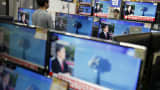 A sales assistant watches TV sets broadcasting a news report on North Korea's nuclear test, in Seoul, January 6, 2016.