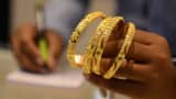 A salesperson calculates the price of gold bracelets at a jewelers.