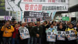 People hold placards showing some of the missing booksellers from Hong Kong's Mighty Current publishing house known for books critical of Beijing, during a protest in Hong Kong on January 10, 2016.
