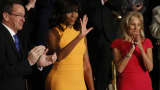 First lady Michelle Obama waves as she stands between Connecticut Governor Dannel Malloy (L) and Vice President Biden's wife Dr. Jill Biden (R) as they attend U.S. President Barack Obama's State of the Union address to a joint session of Congress in Washington, January 12, 2016.