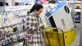 A customer uses her mobile phone as she shops at a Best Buy in Skokie, Ill.