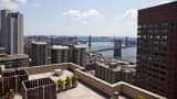 A view of Manhattan Bridge, rear, and Brooklyn Bridge, as seen from the roof terrace of a luxury condo building in New York.