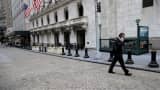 A trader talks on the phone as he walks outside the New York Stock Exchange.