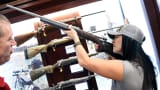 A woman tries out a rifle at a National Shooting Sports Foundation's Shooting, Hunting, Outdoor Trade Show in Las Vegas.