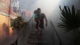 A man walks away from his home with his son as health workers fumigate the Altos del Cerro neighborhood as part of preventive measures against the Zika virus and other mosquito-borne diseases in Soyapango, El Salvador January 21, 2016.