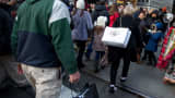 Pedestrians carry shopping bags while walking along 5th Avenue in New York.