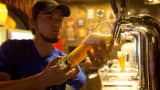 A barman serves a glass of craft beer in Ecuador