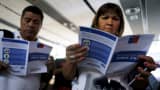People read zika virus flyers from an information campaign by the Chilean Health Ministry at the departures area of Santiago's international airport, Chile January 28, 2016.