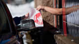 An employee hands a customer their order at the drive-thru window of a Wendy's restaurant in Peoria, Illinois.