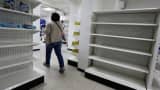 A woman walks past empty shelves at a drugstore in Caracas, Venezuela, February 23, 2016.