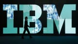 A woman walks past the IBM logo