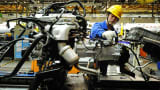 An employee works on an engine at the assembly line of a car factory in Qingdao, China.