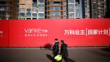 Two citizens pass by Vanke's buildings near the explosion site happened on August 12 at Tianjin Binhai New Area which brought at least 165 people including workers, citizens and firefighters into death on February 4, 2016 in Tianjin, China.
