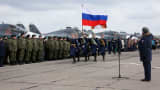 In this photo provided by the Russian Defense Ministry Press Service, guards walk past a lineup of troops during a welcome ceremony for Russian military personnel who returned from Syria at an airbase near the Russian city Voronezh, Tuesday, March 15, 2016.