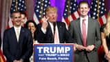Republican U.S. presidential candidate Donald Trump stands between his campaign manager Corey Lewandowski (L) and his son Eric (R) as he speaks about the results of the Florida, Ohio, North Carolina, Illinois and Missouri primary elections.