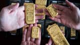 Employees hold mixed-weight Argor-Heraeus SA branded gold bars in this arranged photograph at Solar Capital Gold Zrt. in Budapest, Hungary.
