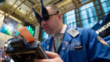 A trader wearing novelty glasses in the shape of champagne bottles works at the New York Stock Exchange (NYSE) in New York.