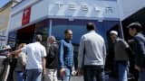 People wait in line at a Tesla Motors dealership to place deposits on the electric car company’s mid-priced Model 3 in La Jolla, California, March 31, 2016.