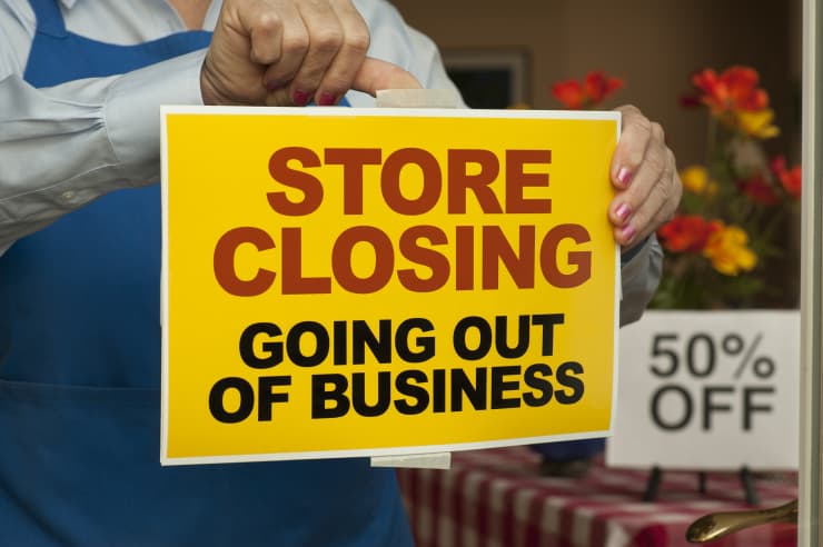 Premium: Store Closing sign being taped on door