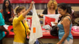 Employees assist customers at the checkout counter of a J.C. Penney store.
