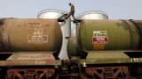A worker walks atop a tanker wagon to check the freight level at an oil terminal on the outskirts of Kolkata, India.