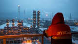An employee looks out over the illuminated petroleum cracking complex at the Lukoil-Nizhegorodnefteorgsintez oil refinery in Russia.