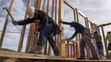 Contractors secure a wall section on a home under construction at the Toll Brothers Cantera at Gale Ranch housing development in San Ramon, Calif.