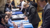 Job seekers, right, speak with recruiters at the San Jose Career Fair in California.