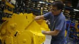 A worker assembles components for a New Holland Ltd. round baler at the company's Haytools factory in New Holland, Pennsylvania.