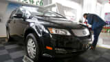 A customer checks a BYD e6 electric car at a dealership in Beijing, China.