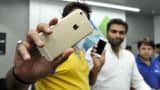 People hold up Apple iPhone 6 and iPhone 6 Plus devices in Noida, India.