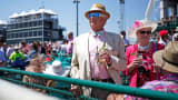 Racegoers sit in the stands at Churchill Downs while watching afternoon races on the eve of the Kentucky Derby in Louisville, Kentucky.