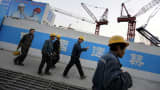 Workers walk outside a construction site in Beijing's central business district.
