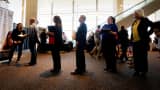 Job seekers wait to talk to a recruiter at a health care job fair sponsored by the Colorado Hospital Association in Denver.