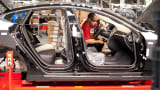 An employee works on a Telsa Motors Model S sedan as it makes its way along an assembly line at company's assembly plant in Fremont, California.