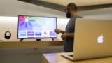 An Apple employee works near a screen with the new Apple TV