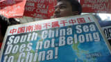 A protestor holds a placard at a rally in front of the Chinese Consulate in Manila's financial district on July 7, 2015, denouncing China's claim to most of the South China Sea including areas claimed by the Philippines.