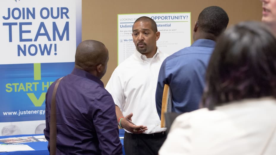 A Just Energy Group representative speaks with job seekers during the Best Hire Career Fair in Houston, Texas.