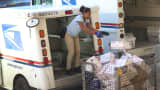 A U.S. postal worker unloads her delivery truck in Miami, Florida.