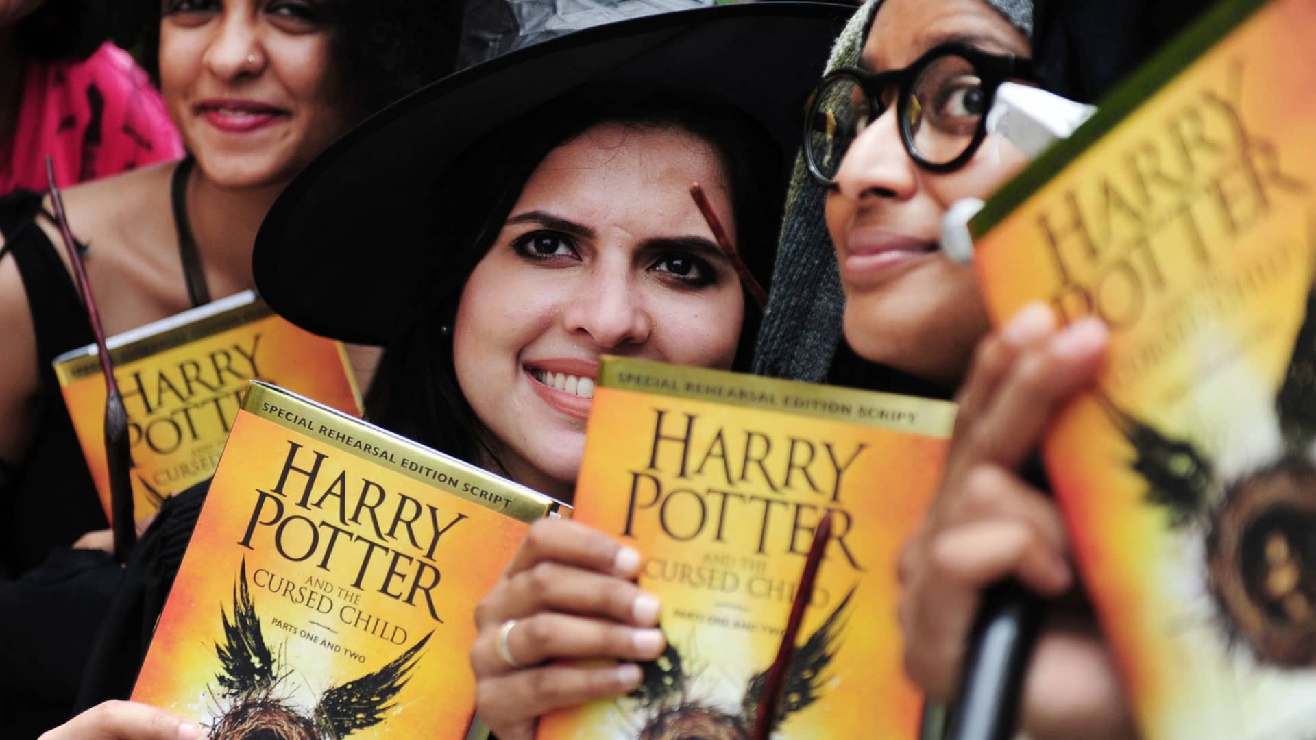 People pose for photgraphers with copies of J.K. Rowlings new book 'Harry Potter and the Cursed Child' during an event to mark the book launch at a mall in Chennai, India on July 31, 2016.