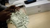 A customer uses cash to pay for Apple iPads at the Apple store on 5th Avenue in New York.