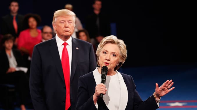 Hillary Clinton speaks as Donald Trump looks on during the town hall presidential debate at Washington University on October 9, 2016, in St Louis.
