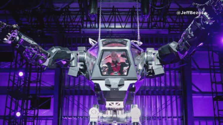 Jeff Bezos takes a ride in a 13-foot robot