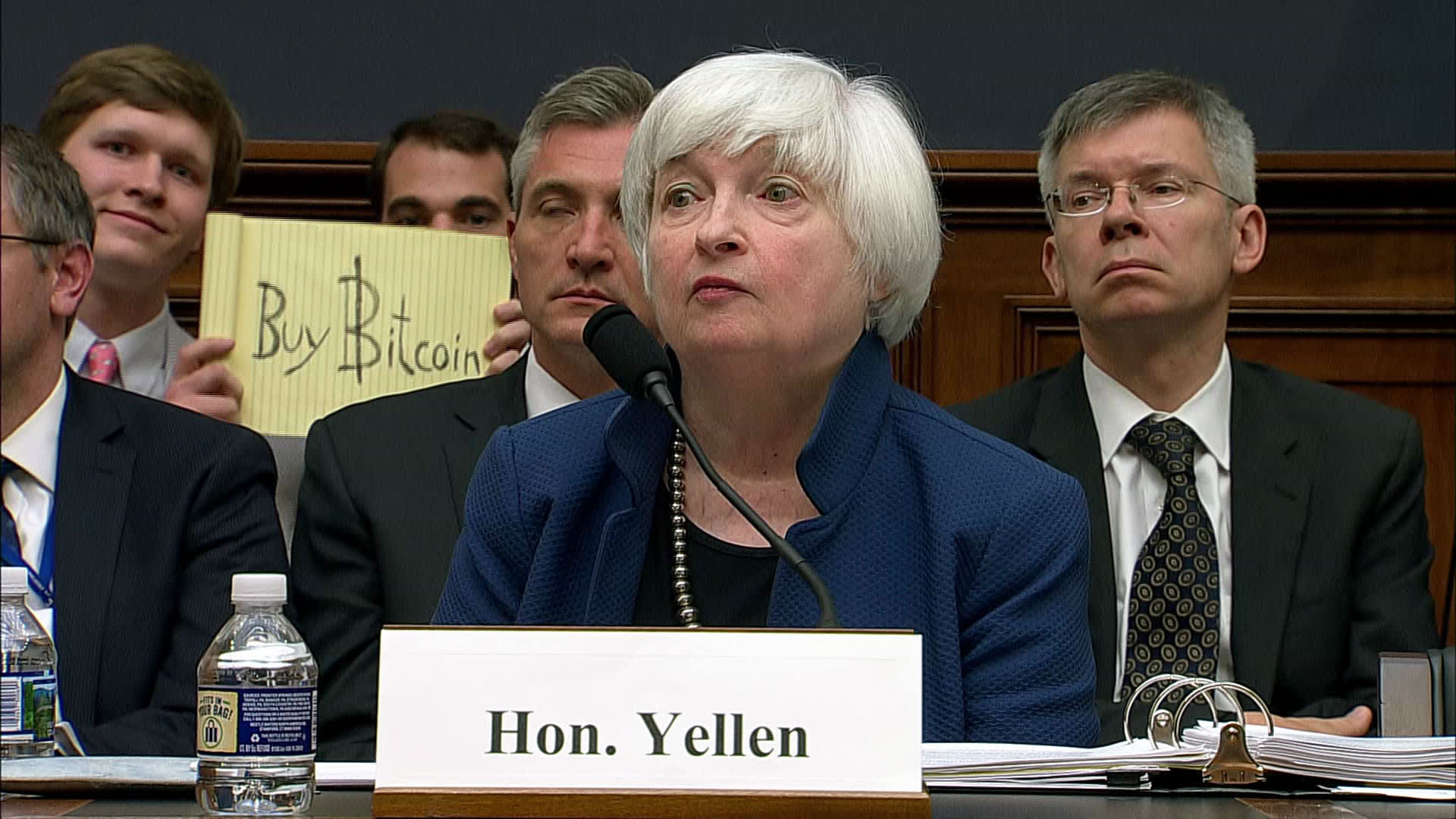Someone holds up 'buy bitcoin' sign during Yellen testimony to Congress